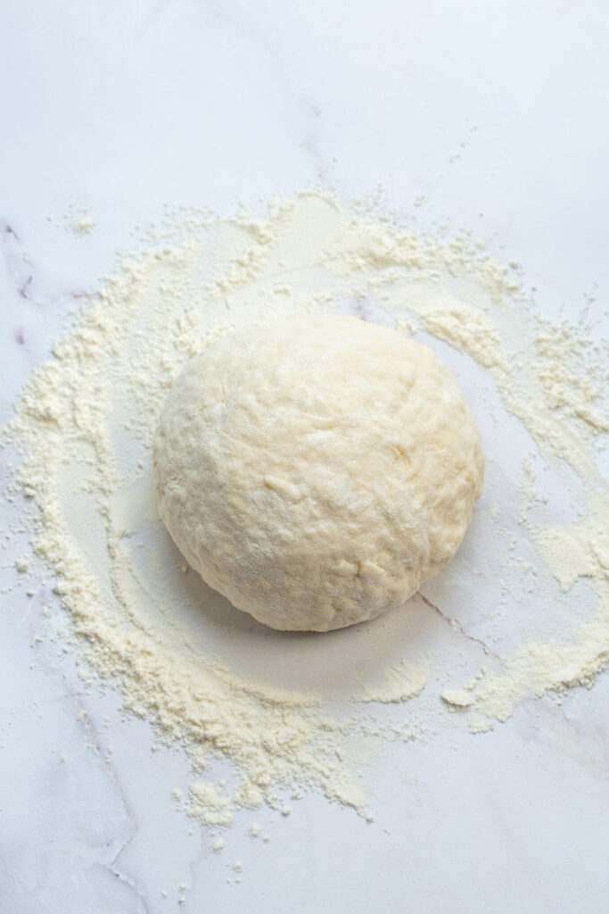 Ball of Greek yogurt bagel dough on a floured surface
