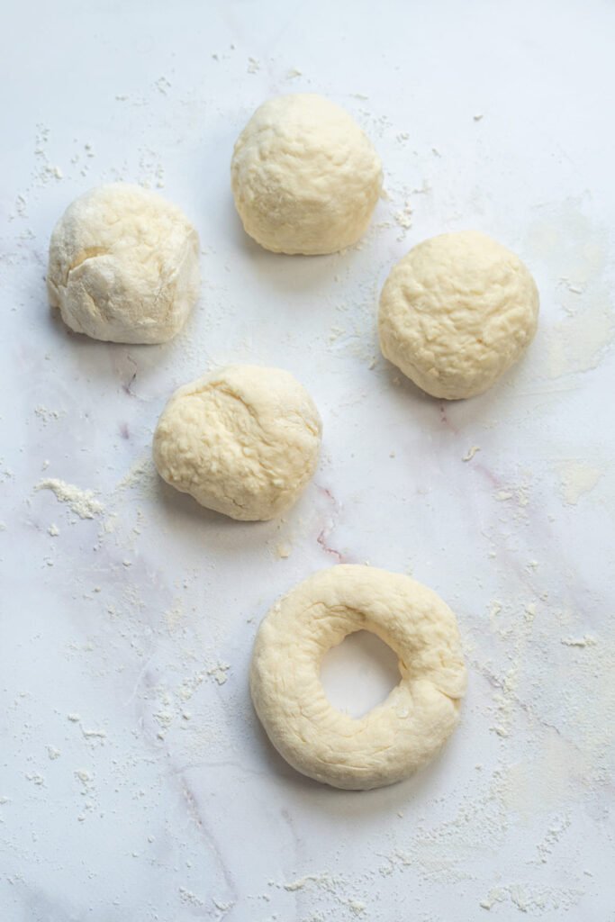 Divided bagel dough rolled into balls and shaped into rings