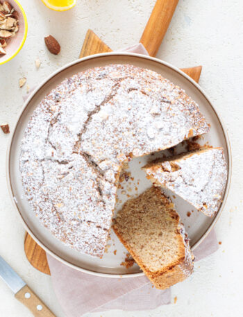 Baked Italian almond orange cake with powdered sugar and slice cut out