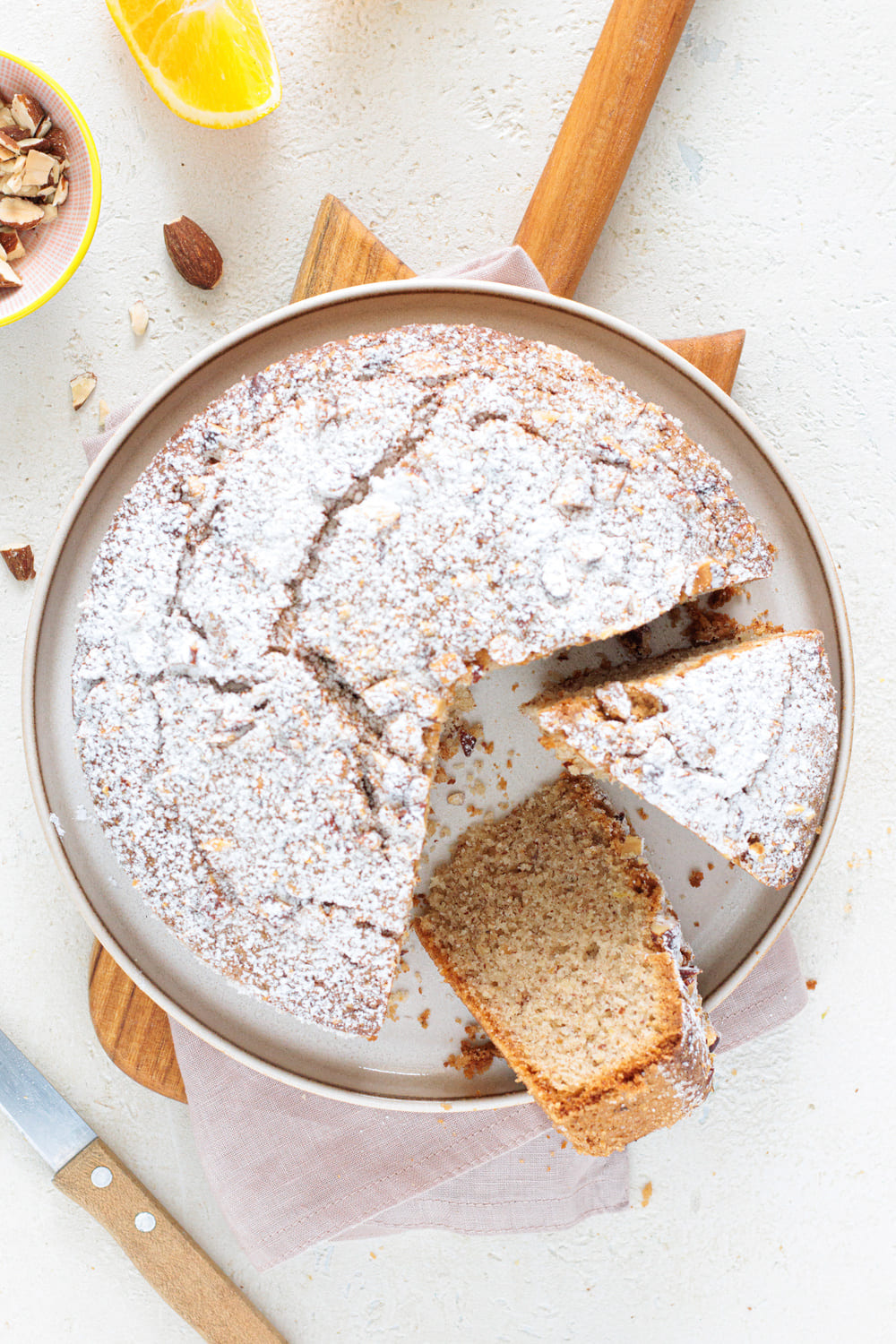 Baked Italian almond orange cake with powdered sugar and slice cut out