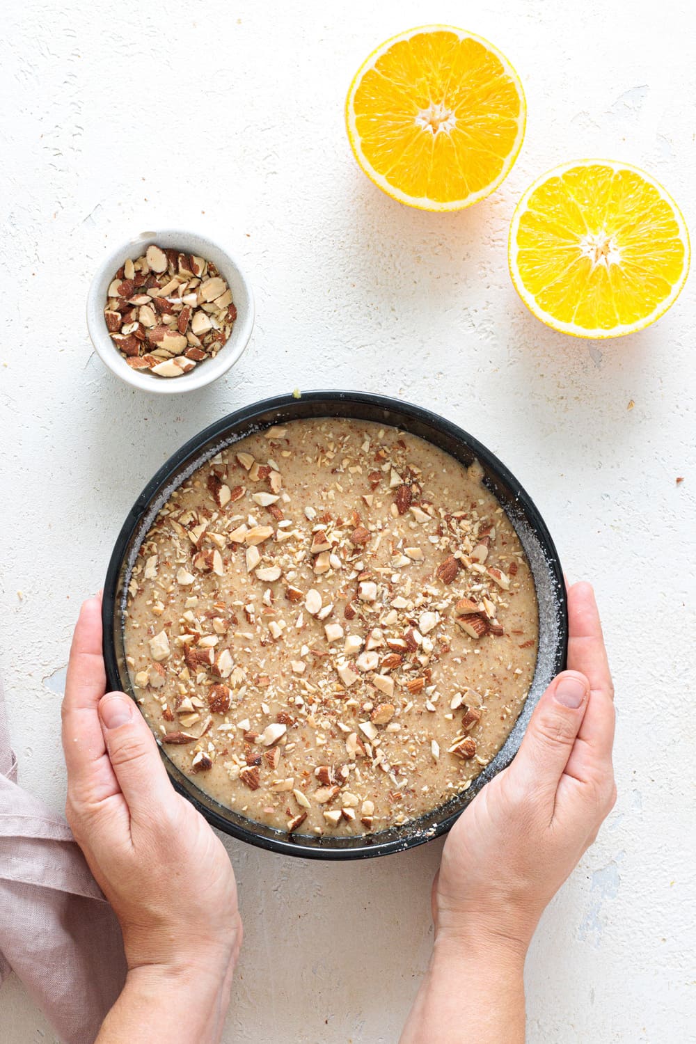 Cake batter in pan topped with chopped almonds