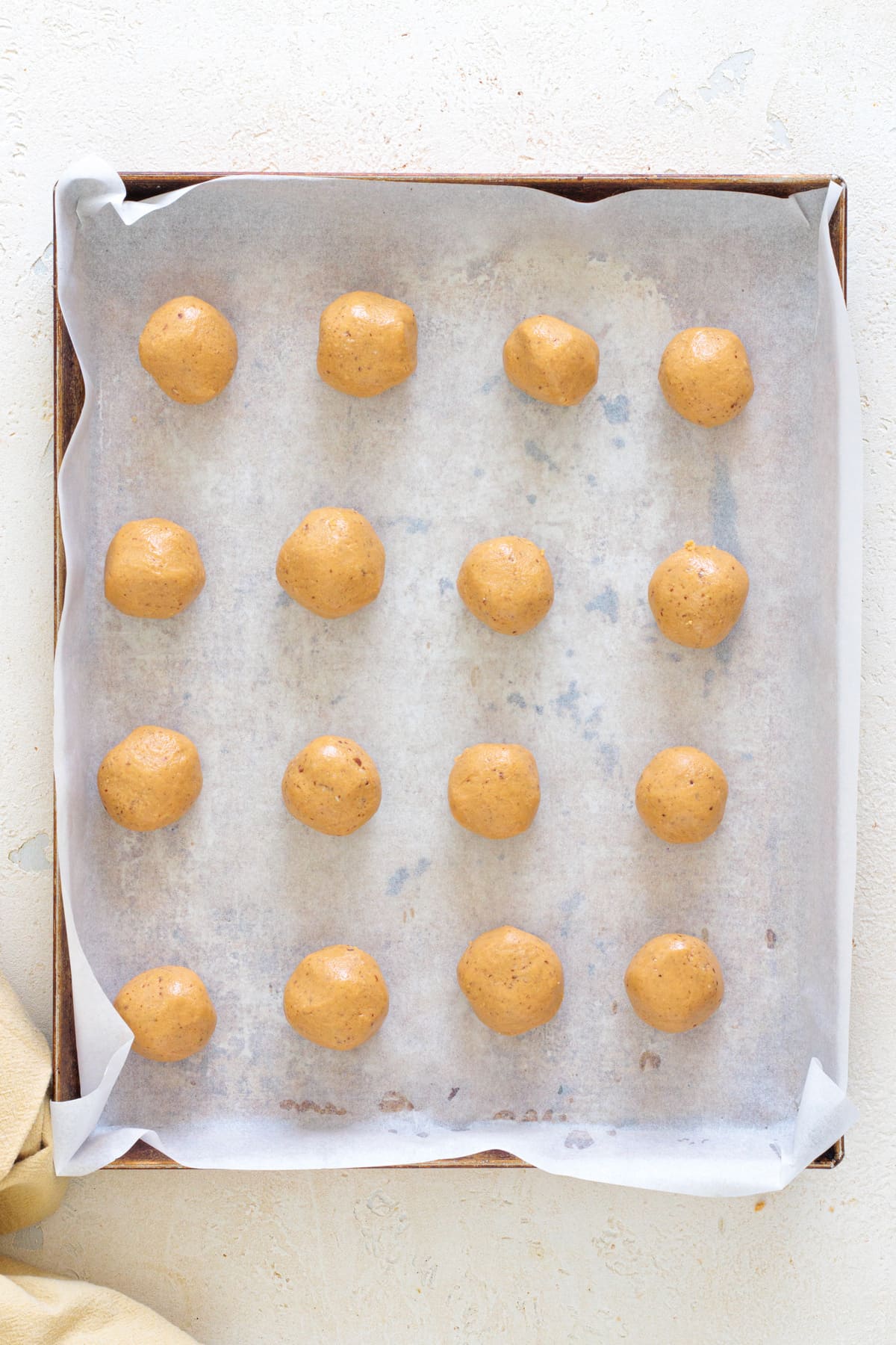 Shape the chilled dough into small, even balls on a lined tray.
