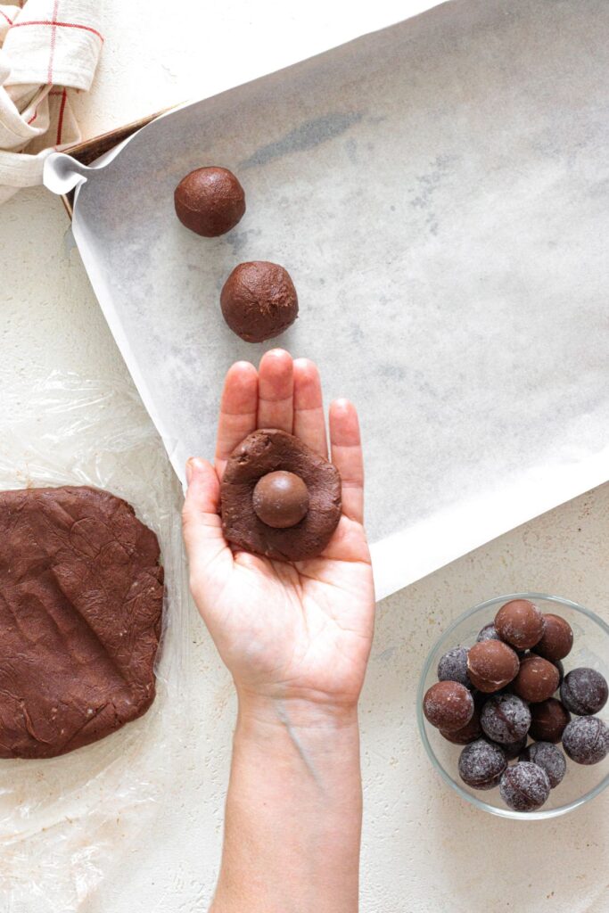 Frozen chocolate placed in the center of flattened cookie dough