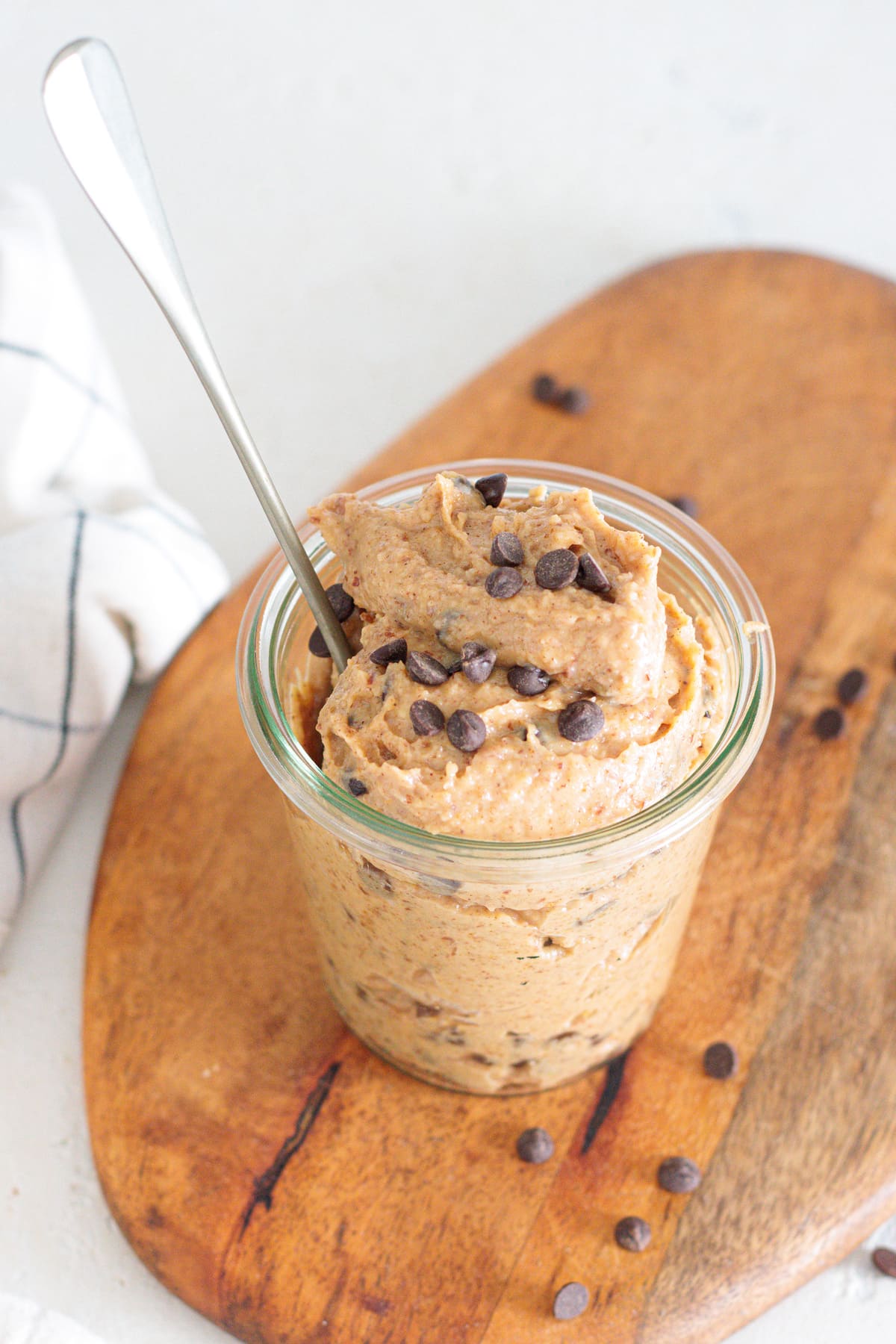 Glass jar of homemade greek yogurt cookie dough with chocolate chips on top.