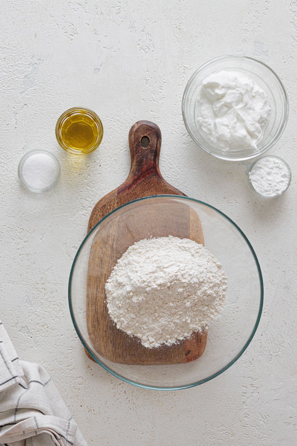 Ingredients for Greek yogurt pizza dough – flour, Greek yogurt, olive oil, salt, and baking powder.