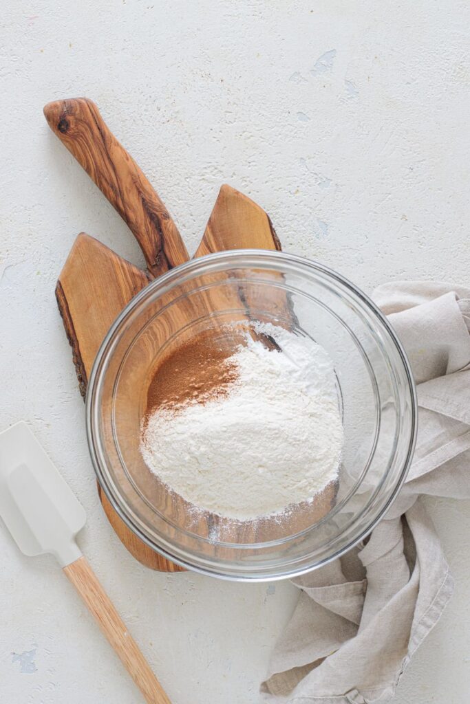 Bowl with flour, cinnamon, and baking powder for oatmeal raisin cookies