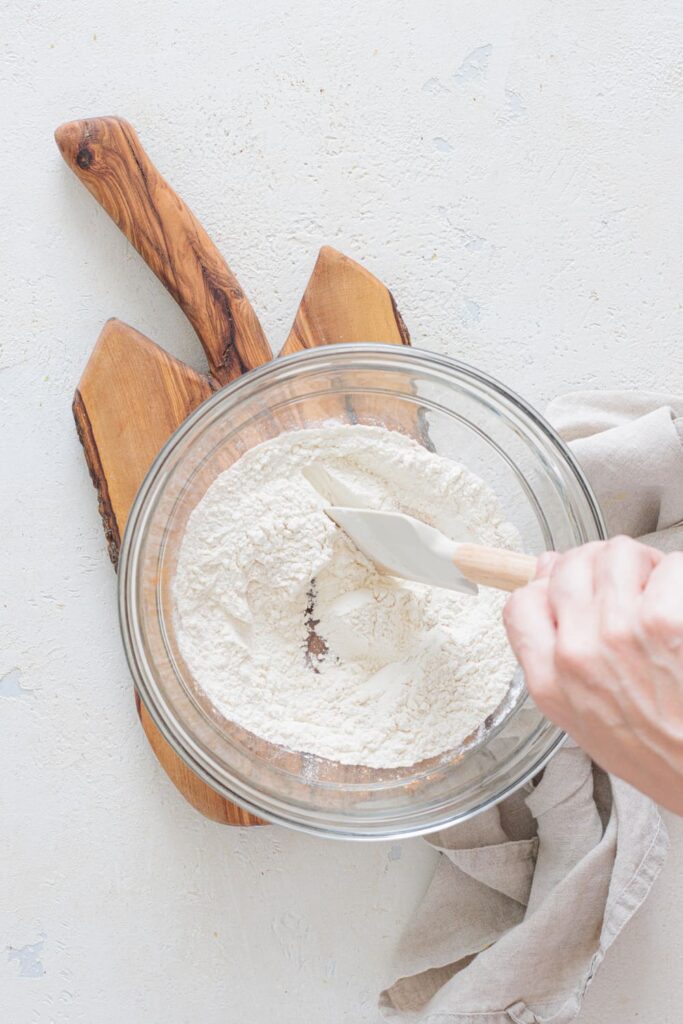 Mixing flour, cinnamon, and baking powder with a spatula
