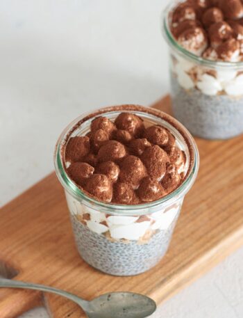 Tiramisu chia pudding jars dusted with cocoa, ready to serve.