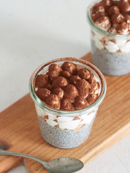 Tiramisu chia pudding jars dusted with cocoa, ready to serve.
