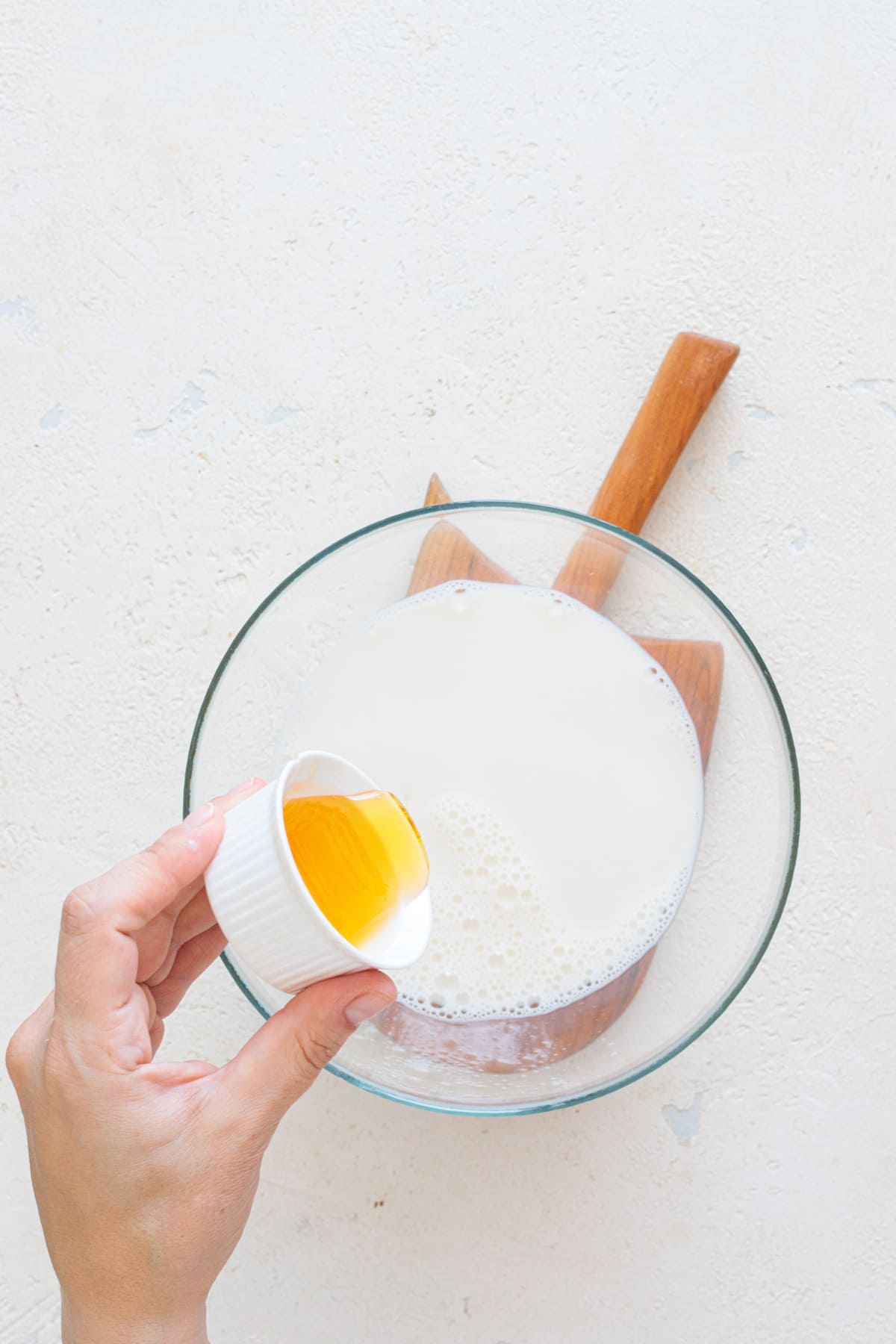 Mixing milk with honey in a bowl.