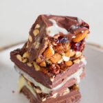 Close-up of homemade nut goodie bars with a smooth vanilla center and nut topping.