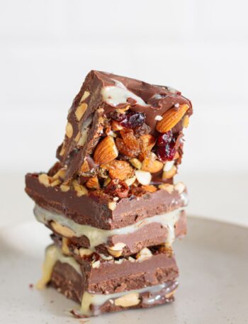 Homemade nut goodie bars stacked with creamy filling and crunchy nuts.