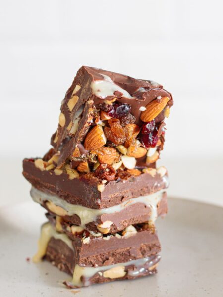 Homemade nut goodie bars stacked with creamy filling and crunchy nuts.