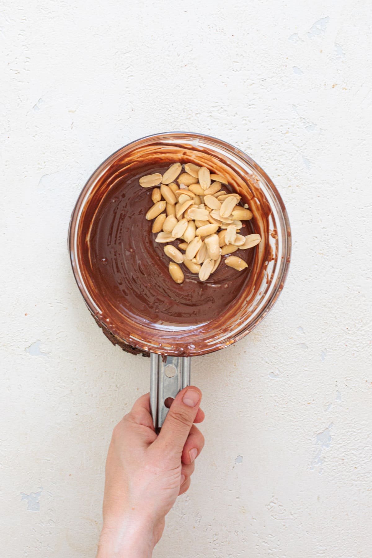 Stir chopped peanuts into the smooth melted chocolate.