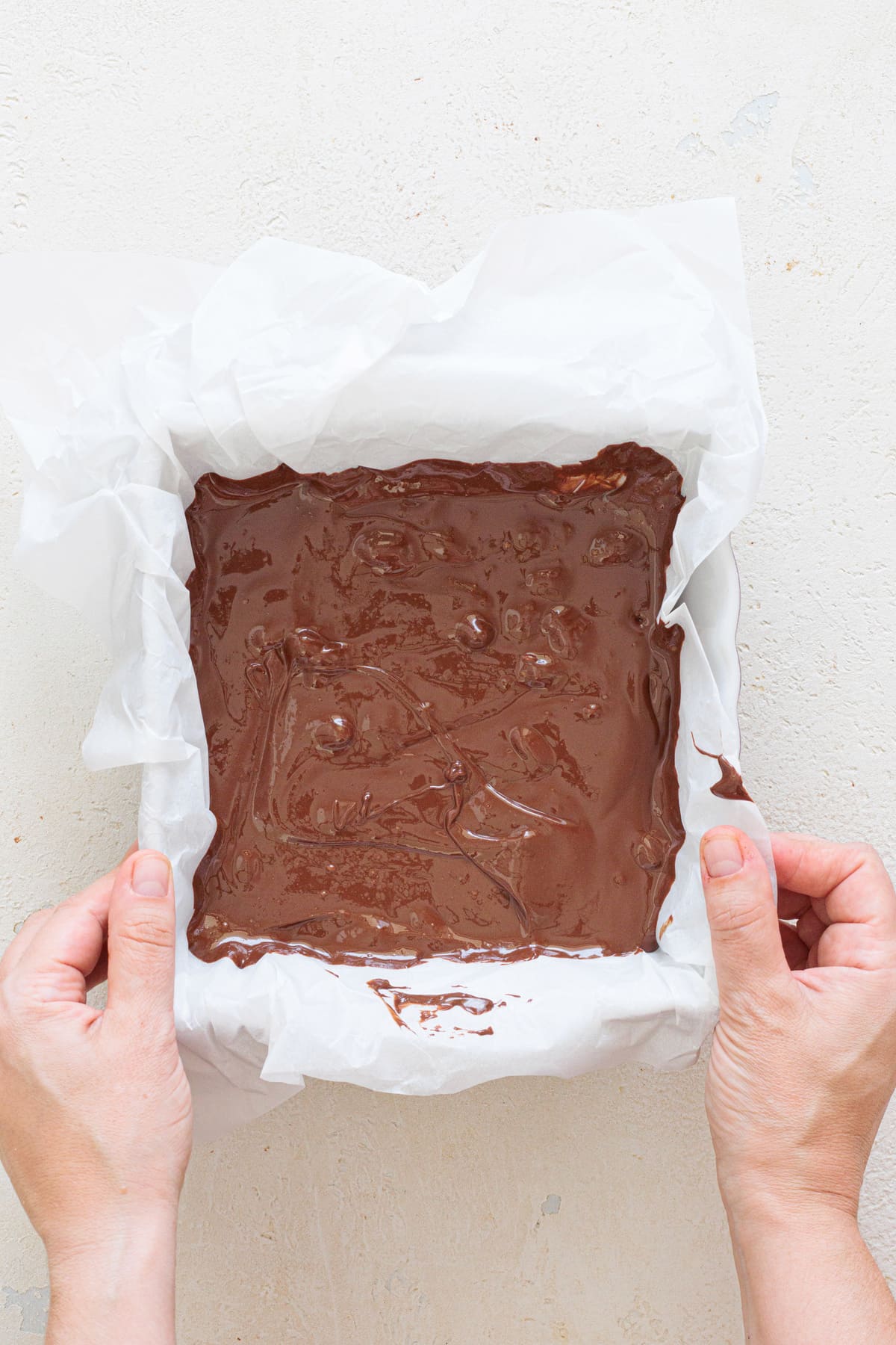 Spread the chocolate-peanut mixture evenly in a lined square pan.