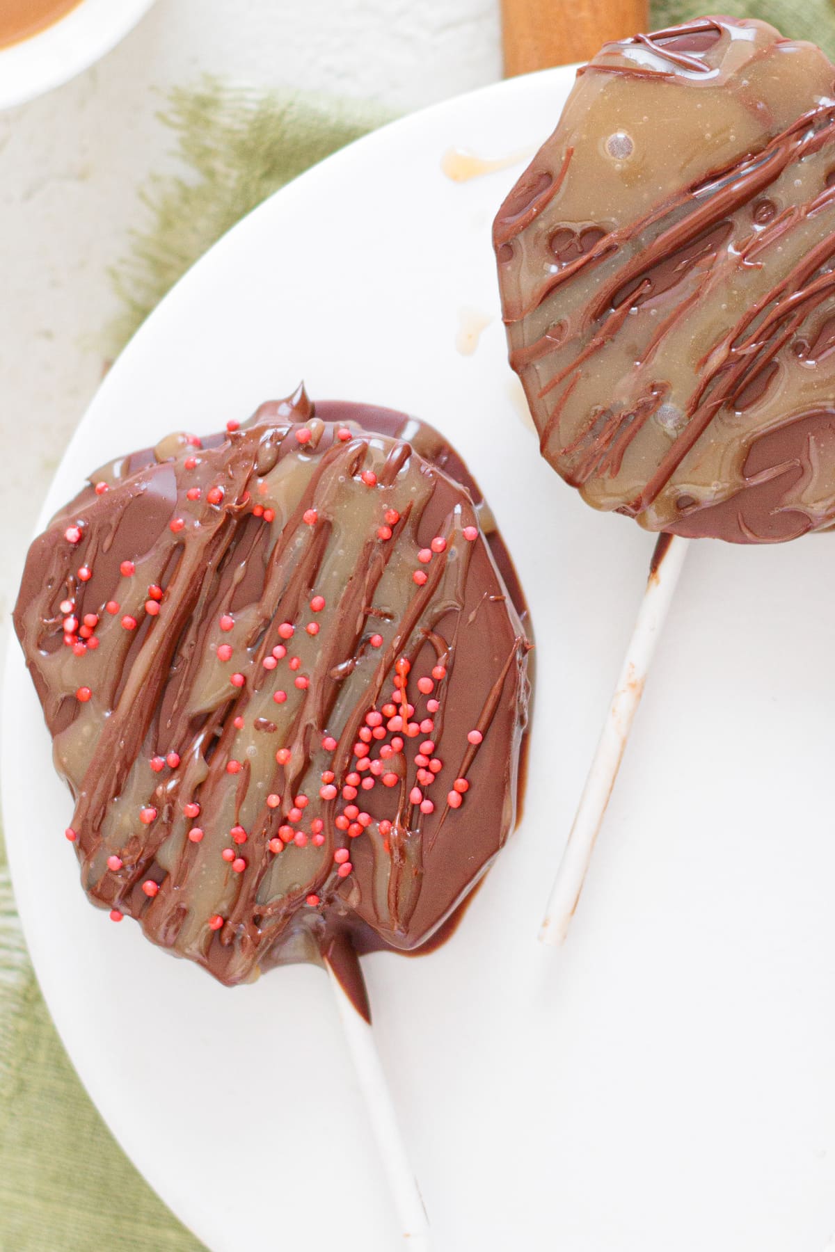 Chocolate-covered Caramel Apple Slices with caramel drizzle.