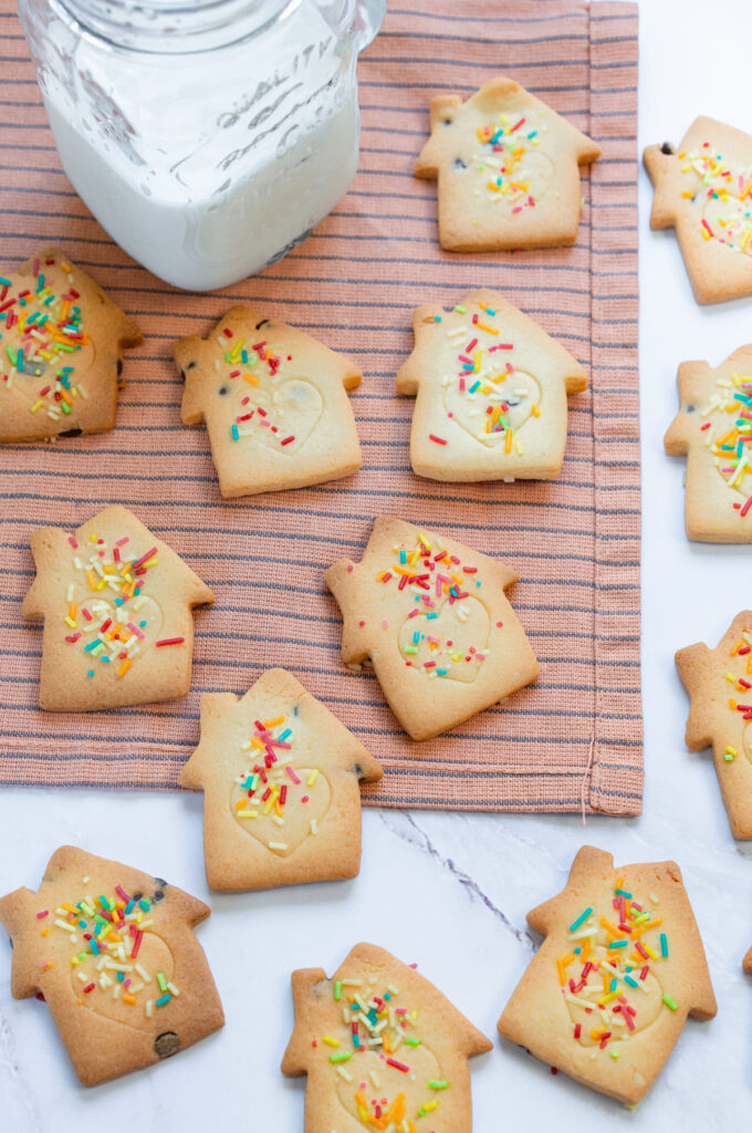 Golden Christmas sugar cookies decorated with colorful sprinkles.