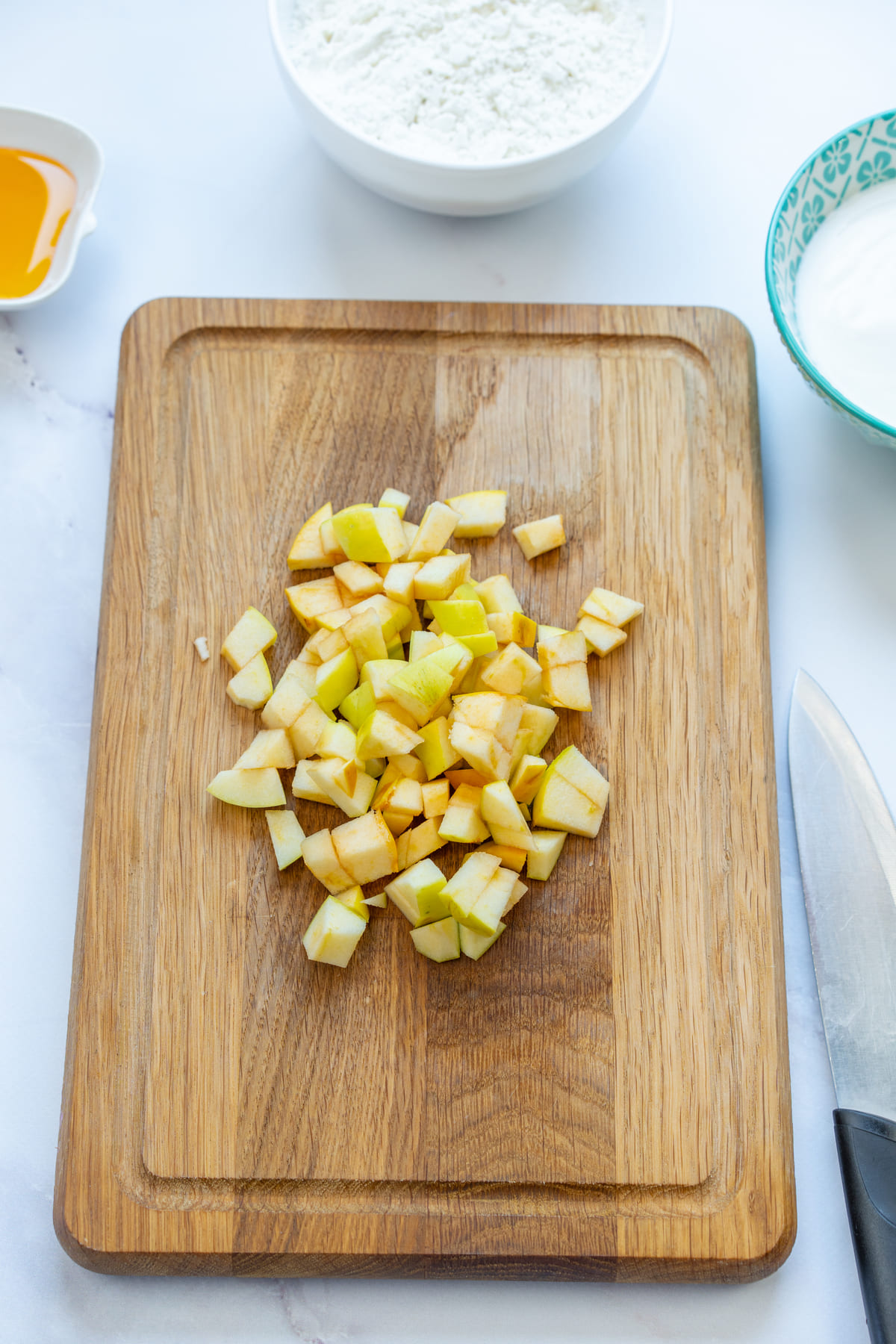 Diced apple on a wooden board for baking rolls