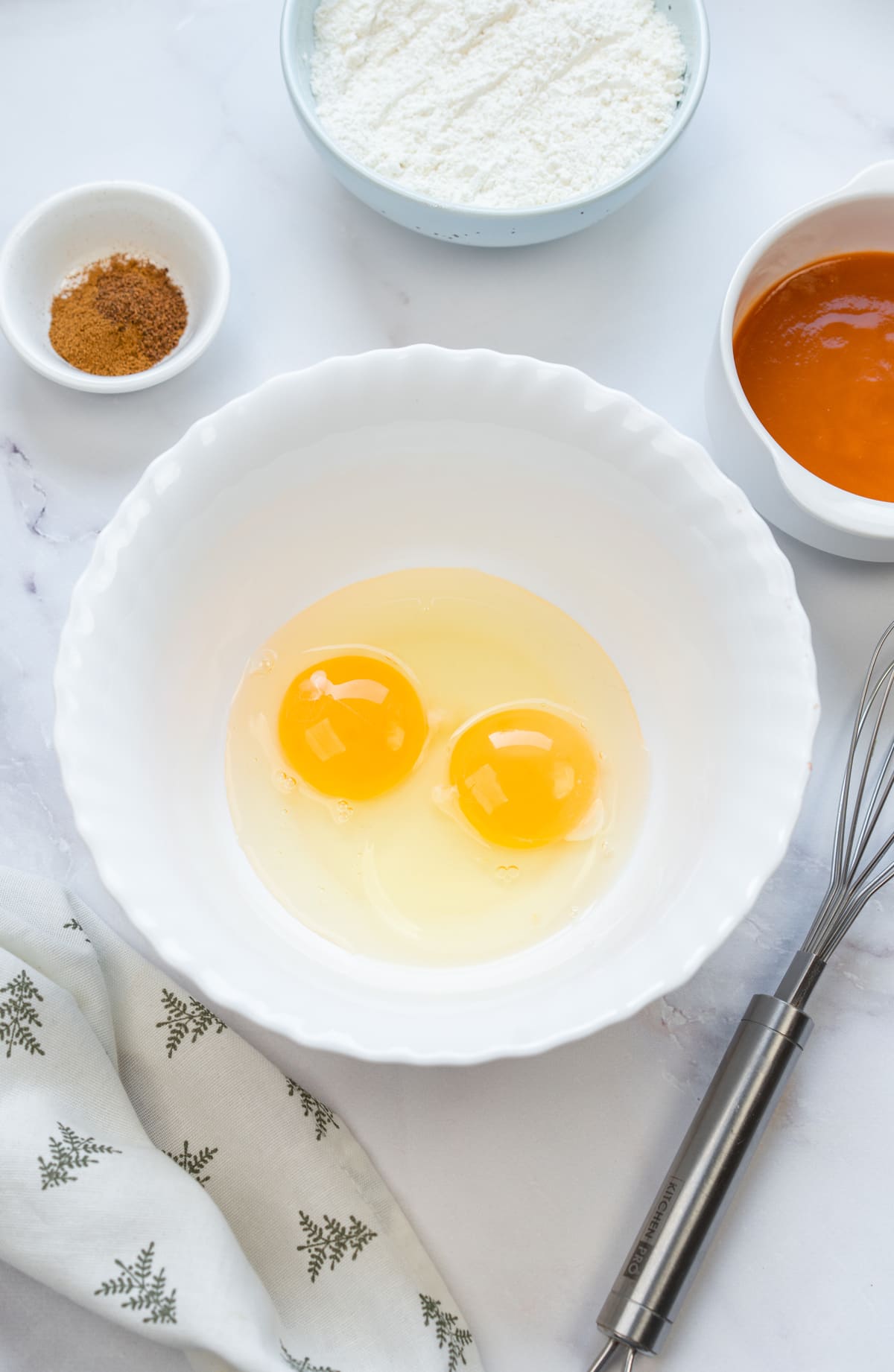 Crack two eggs into a mixing bowl.