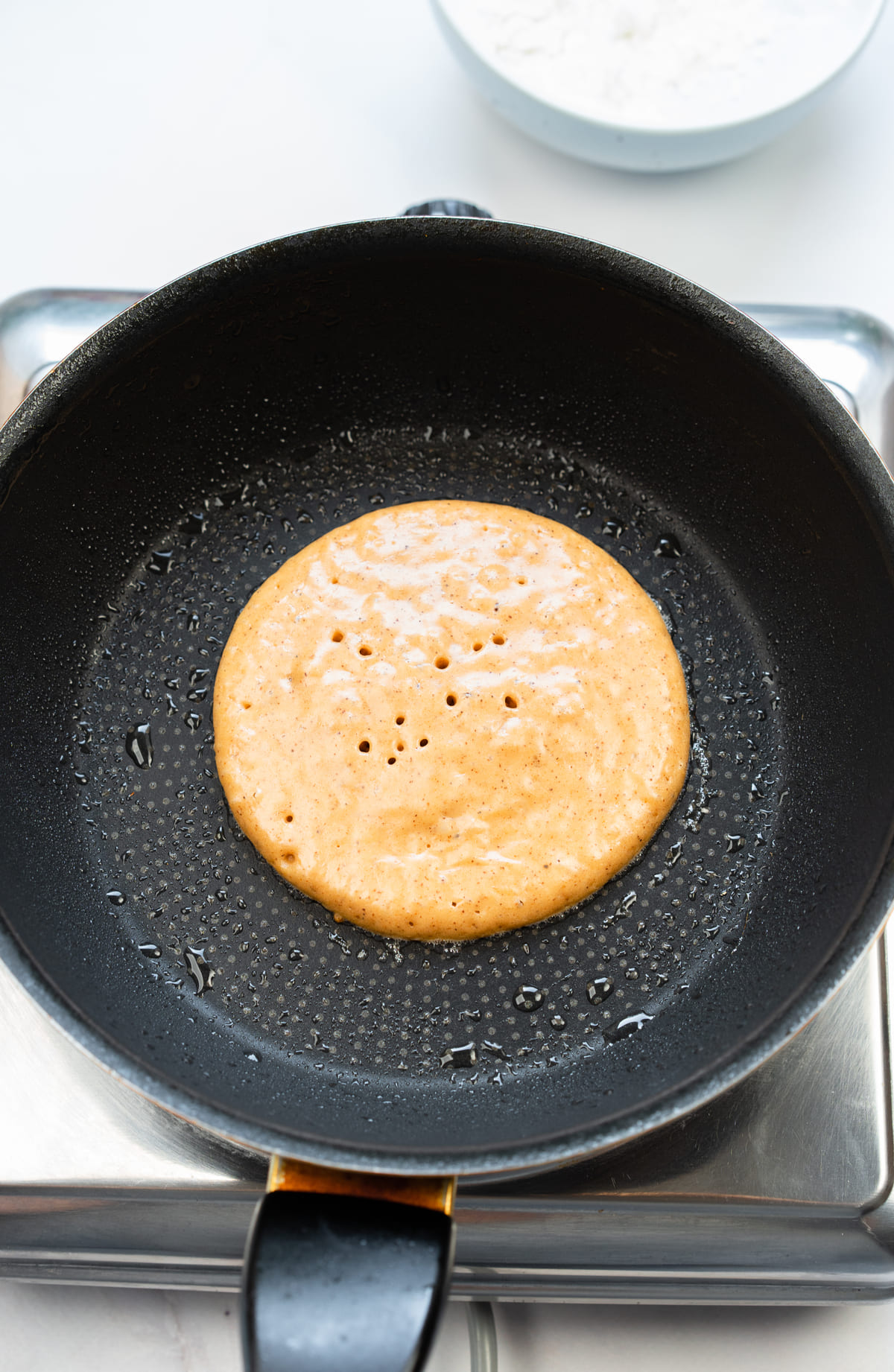 Pour a spoonful of batter onto a preheated non-stick pan.