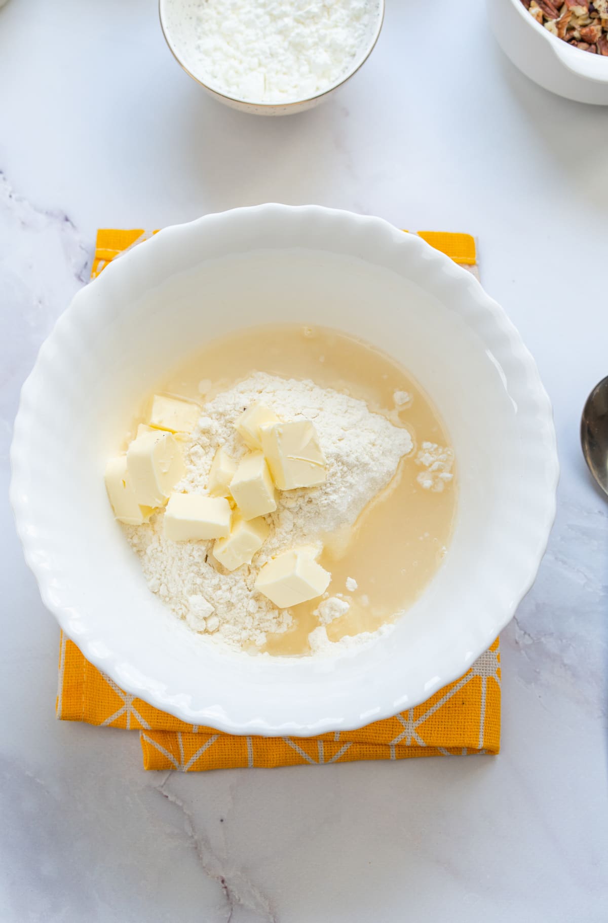 Cold butter, gluten-free flour, and water in a bowl.