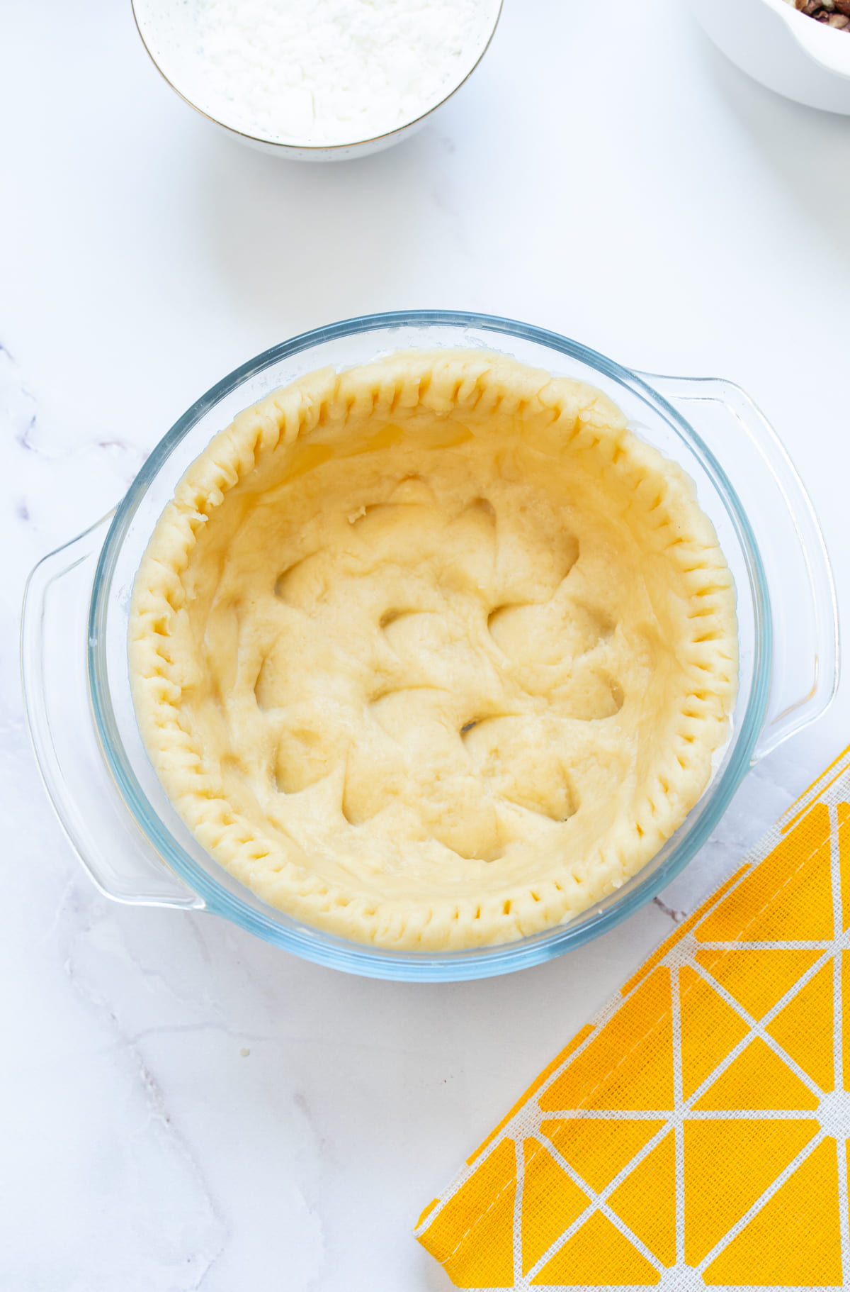 Rolled-out dough pressed into a pie dish.