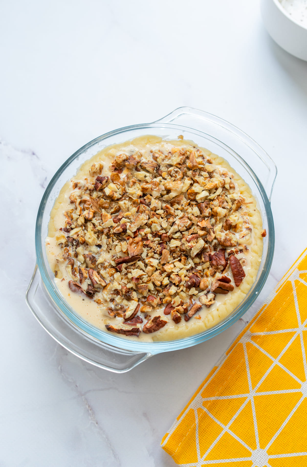 Filling poured into the crust, topped with pecans.