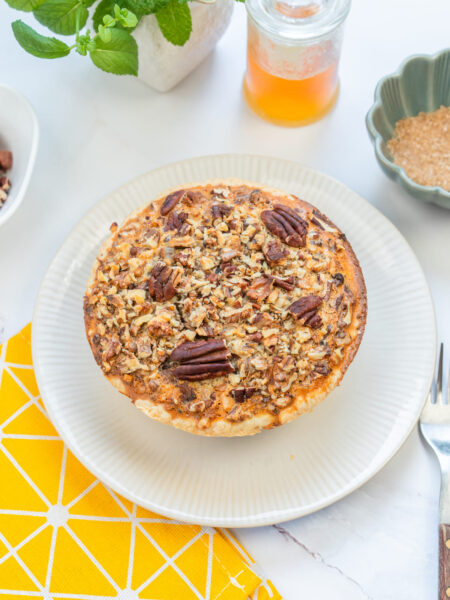Gluten-free pecan pie served whole, topped with toasted pecans for extra crunch.