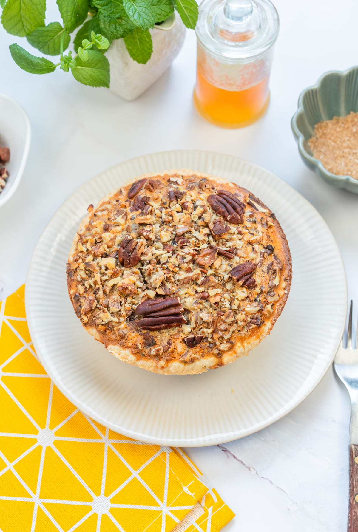 Gluten-free pecan pie served whole, topped with toasted pecans for extra crunch.