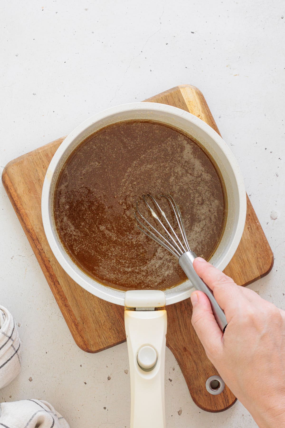 Whisking the melted butter, sugar, and maple syrup mixture.