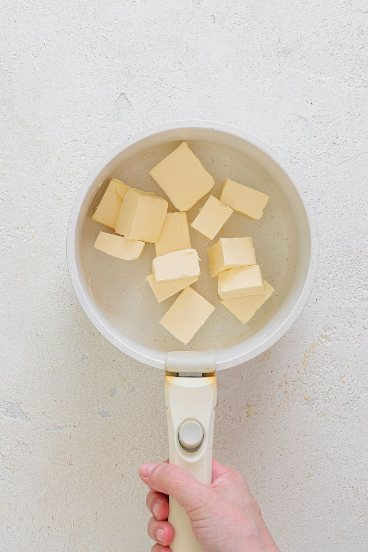 Cubes of butter in a white saucepan ready to melt