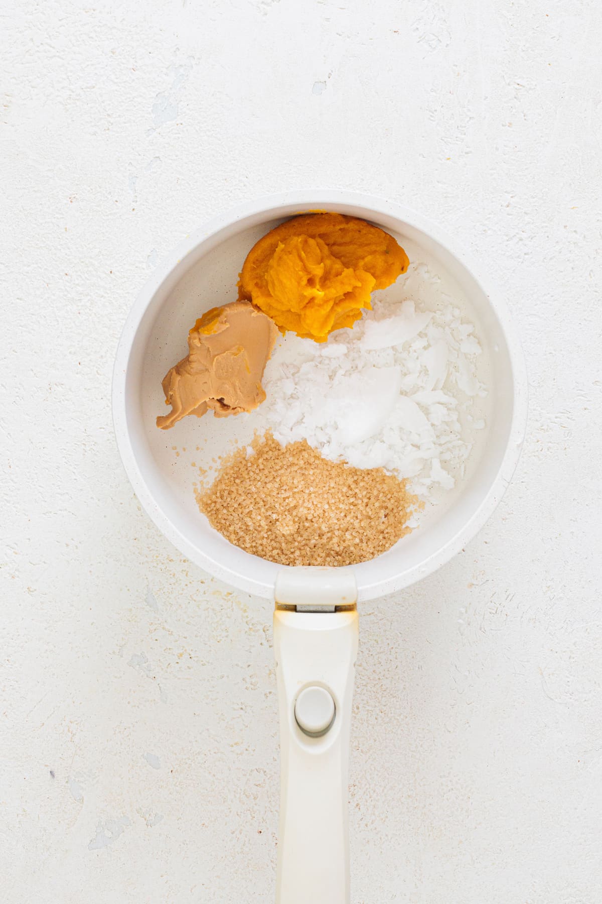 Pumpkin puree, peanut butter, coconut oil, and brown sugar in a saucepan before melting