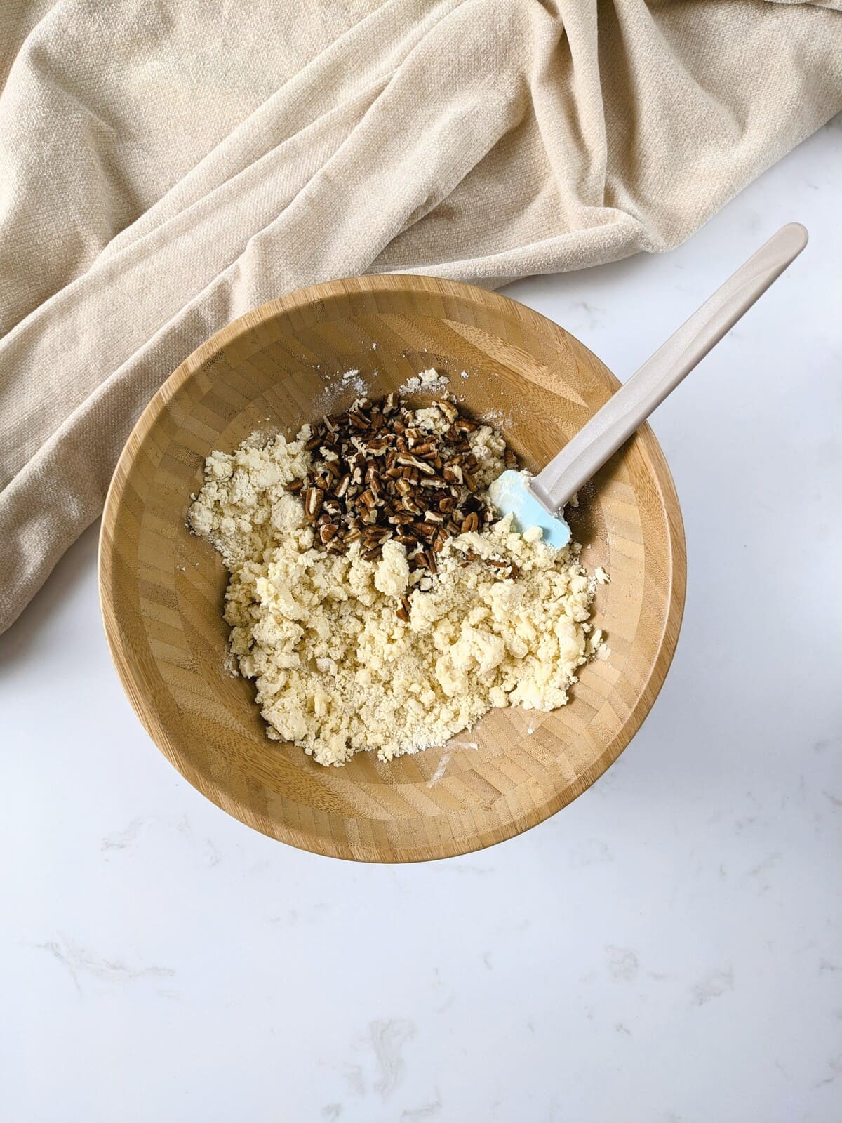 Folding chopped pecans into cookie dough with a silicone spatula