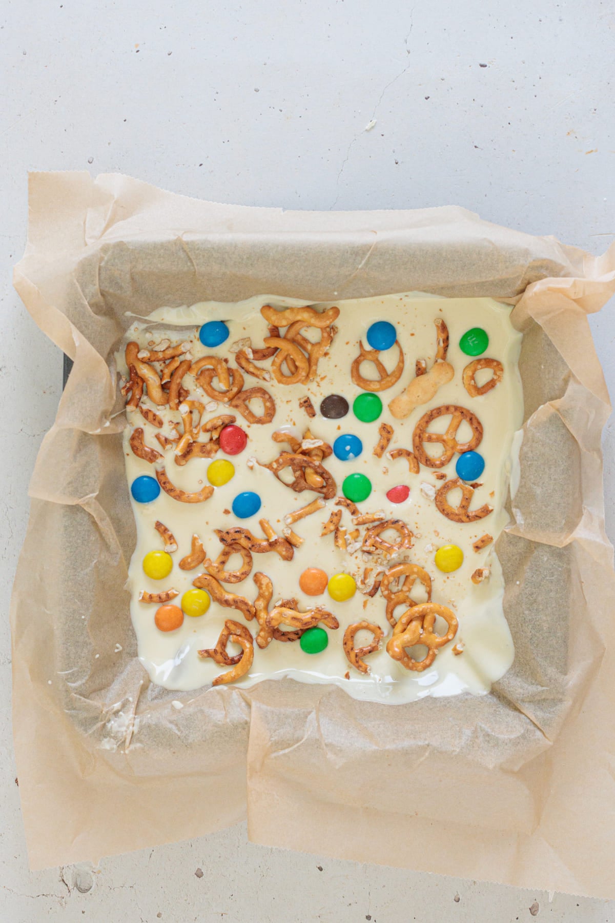 Scatter colorful M&M’s evenly over the pretzel layer.