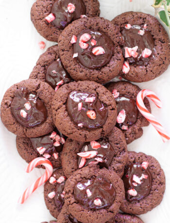 A platter of Chocolate thumbprint cookies topped with creamy ganache and crushed peppermint.