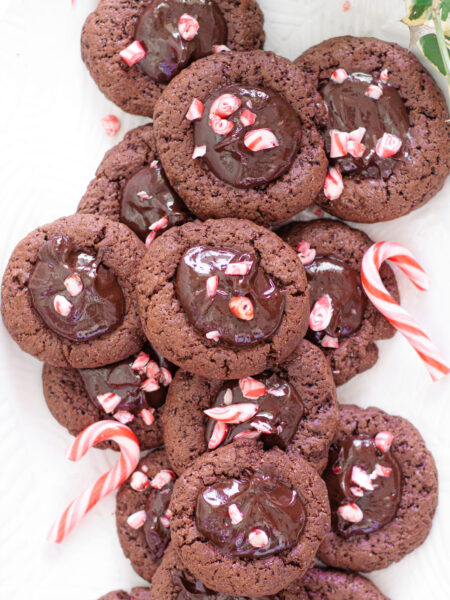 A platter of Chocolate thumbprint cookies topped with creamy ganache and crushed peppermint.