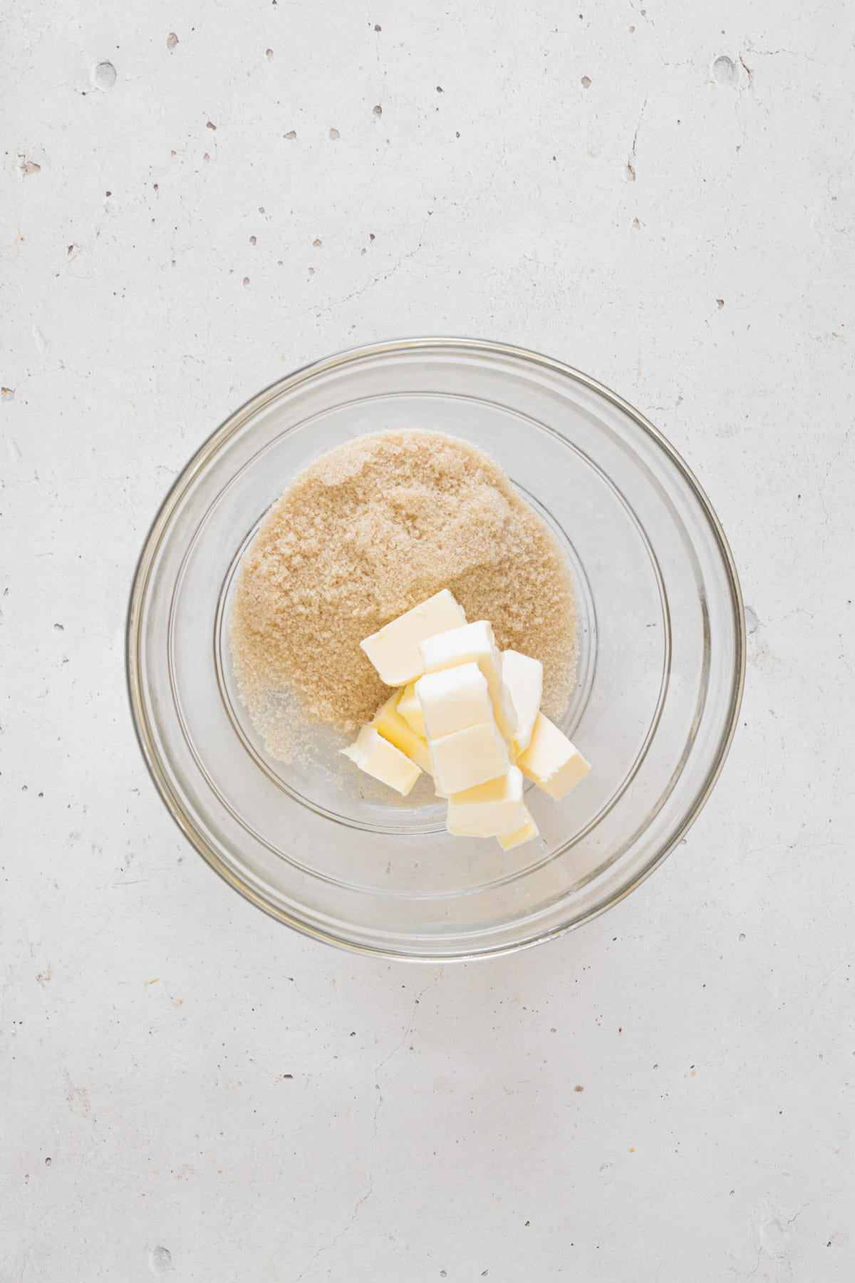 Softened butter and brown sugar in a bowl before creaming.