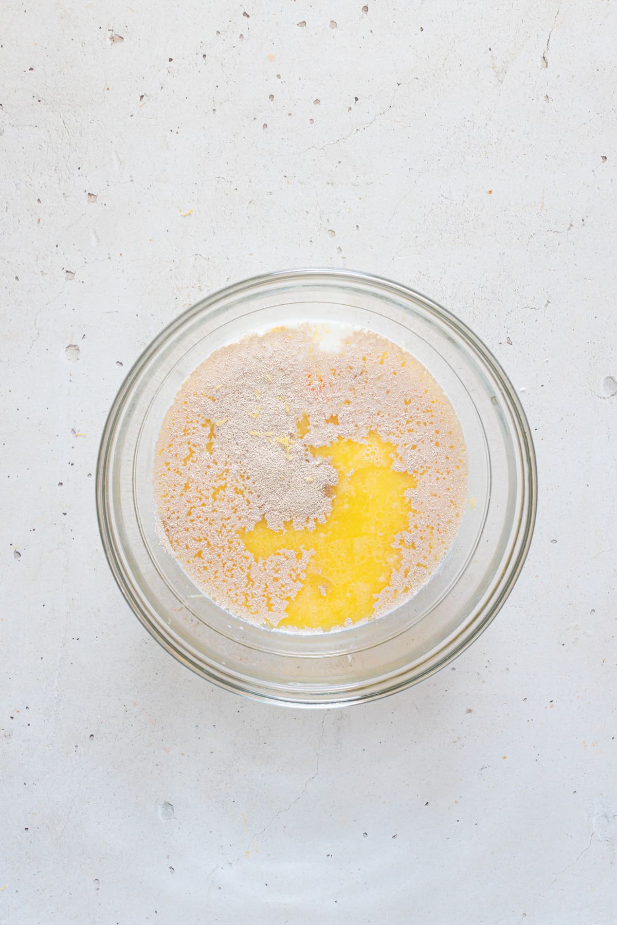 Add warm milk, yeast, egg, sugar, lemon zest, and melted butter to a bowl.