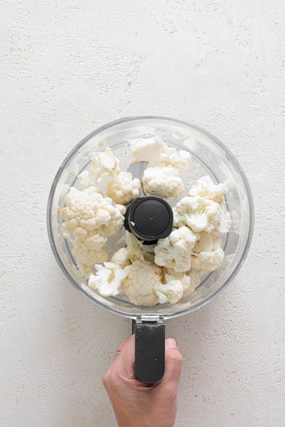 Cut the cauliflower into florets, then add them to a food processor and pulse until they resemble couscous.