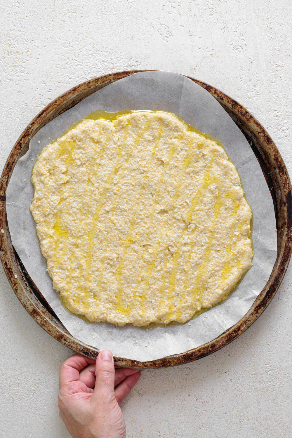 Press the dough into a baking tray with parchment paper until it forms a thin circle.
