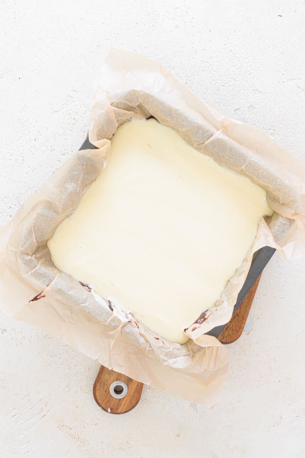 Spread the cheesecake mixture evenly over the brownie layer.