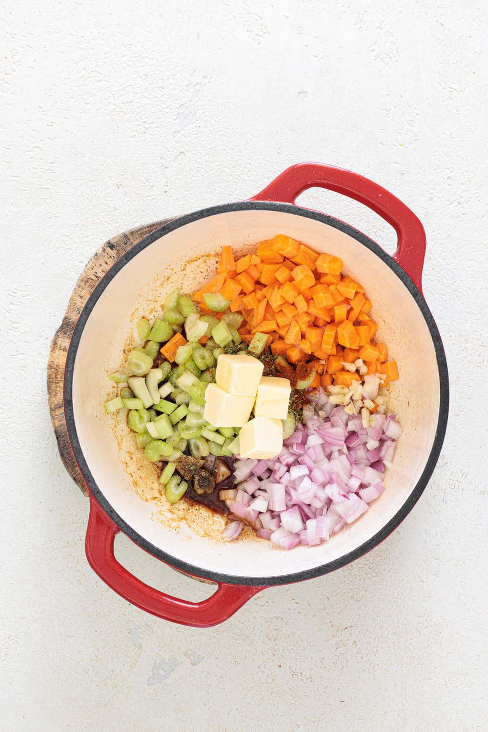 Remove the chicken, then add the butter, onion, carrots, celery, garlic, soy sauce, oregano, paprika, and a bit of pepper to the same pot.
