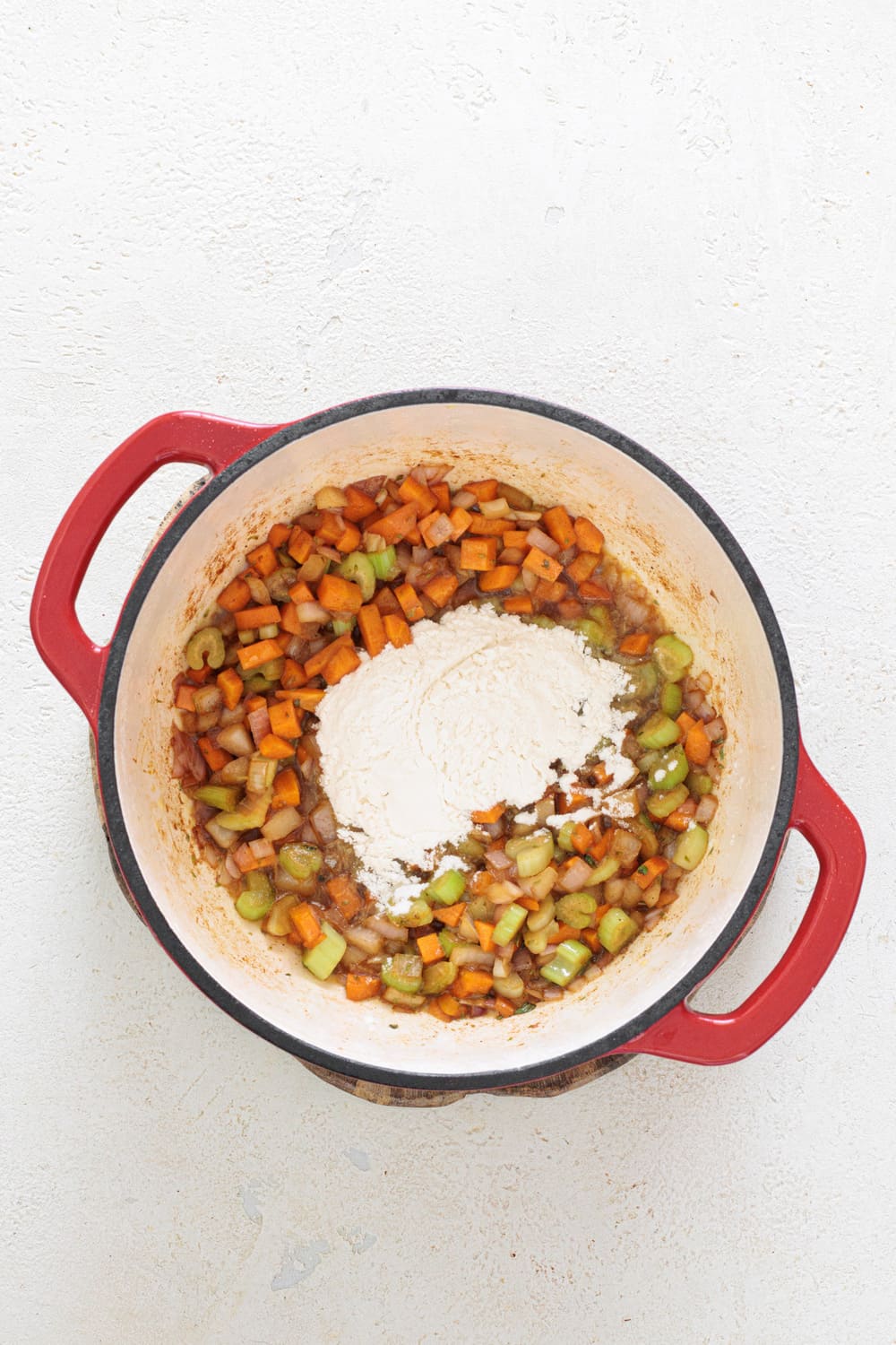 After the vegetables are cooked, add the flour.