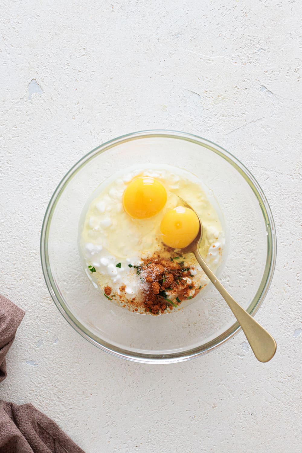 Add the cottage cheese, eggs, spices, and salt into a bowl.