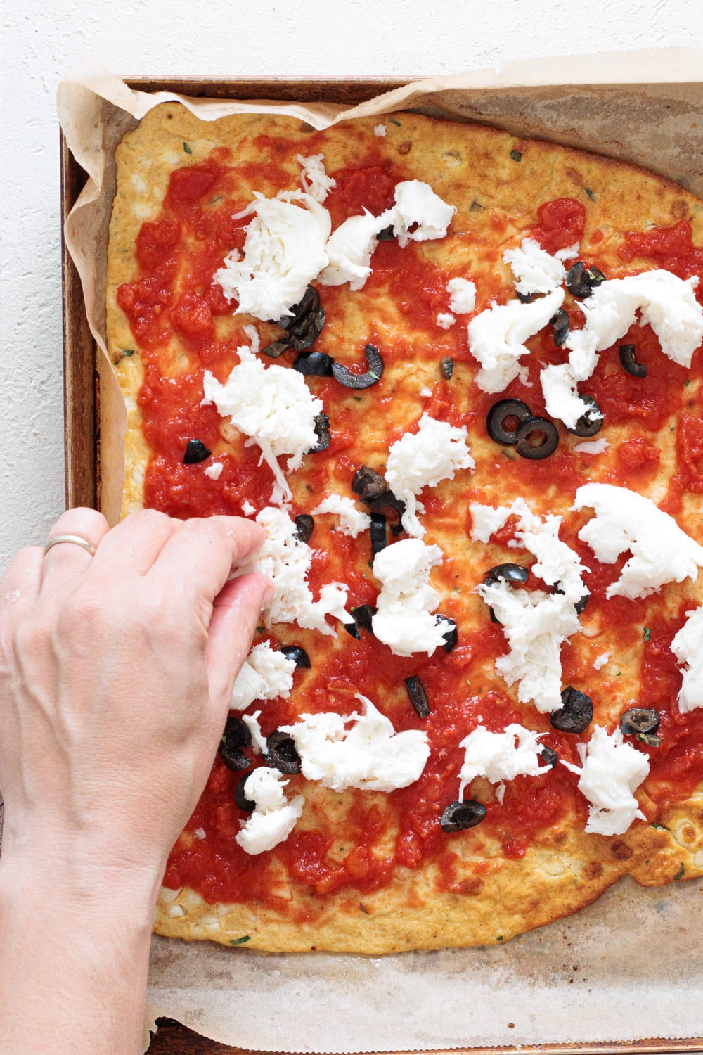 Simple topping of tomato sauce, mozzarella, olives, and oregano.