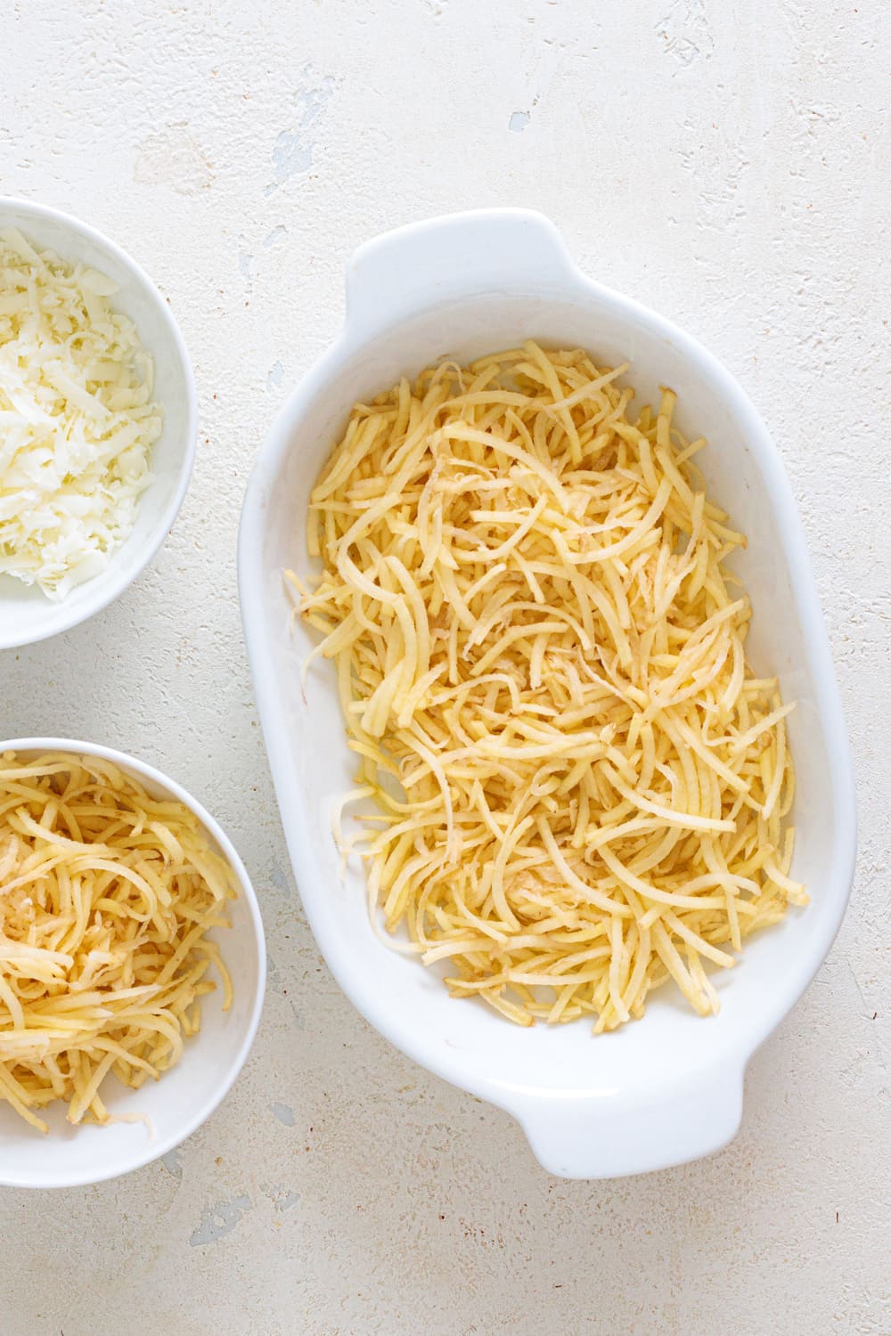 Add the first layer of hash browns to a baking dish lightly greased.