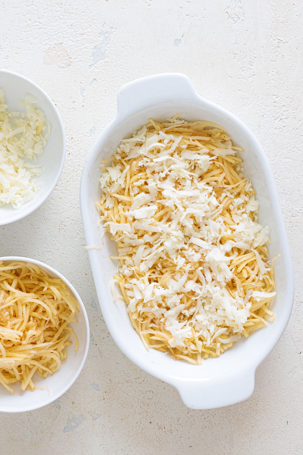 Layer some cheese on top of the hash browns and add a pinch of salt.