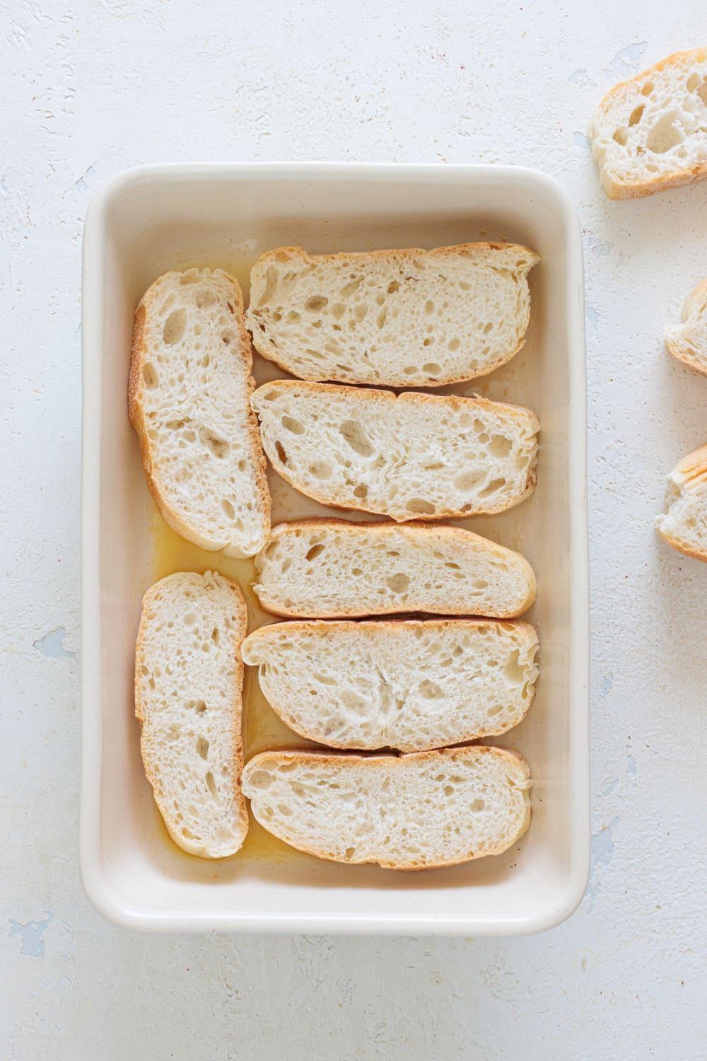 Cut thick slices of bread and place them in the dish to create the first layer.