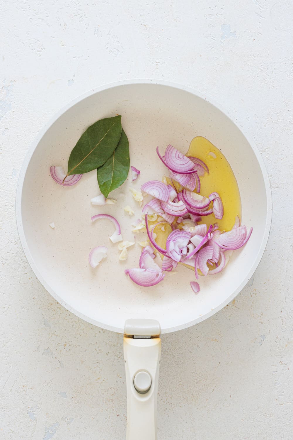 Add olive oil to the pan, then add the garlic and onions, and cook until everything softens.