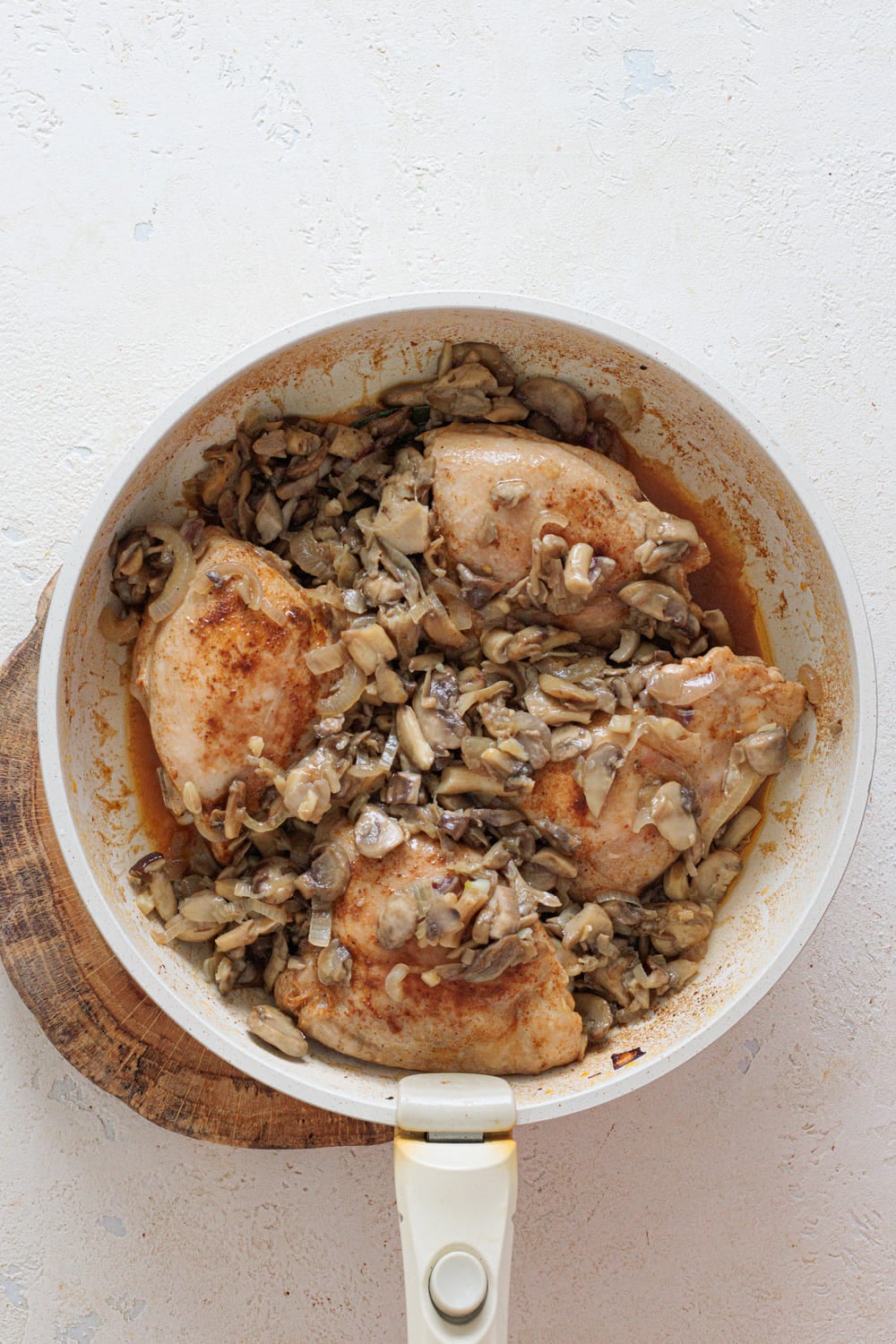 Once the chicken is cooked, add the mushroom-onion mixture back into the pan.